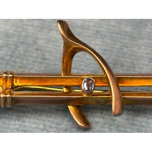 711 - Pretty vintage 9ct gold wishbone brooch inset with a pale blue gemstone. 2.13 gms.