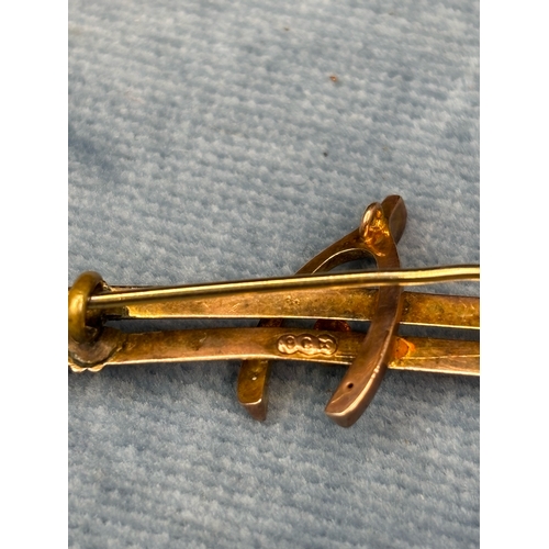 711 - Pretty vintage 9ct gold wishbone brooch inset with a pale blue gemstone. 2.13 gms.