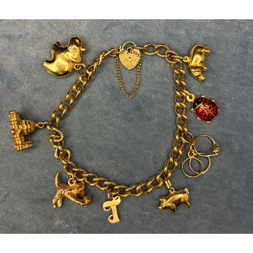 720 - 9 ct gold charm bracelet with padlock clasp and safety chain. 8 charms (some gold). 32gms total weig... 