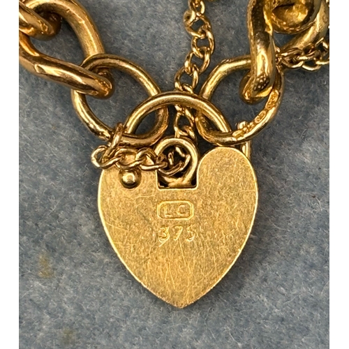 720 - 9 ct gold charm bracelet with padlock clasp and safety chain. 8 charms (some gold). 32gms total weig... 