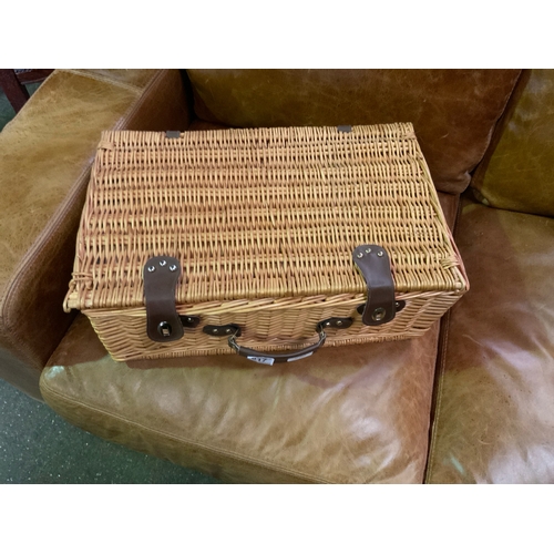 817 - Wicker lined picnic basket with plates, cutlery, bottle opener and plastic wine glasses