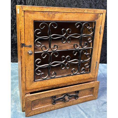 16 - Small wooden desktop cupboard with decorative metal grille in door and a drawer below, approx 30.5cm... 