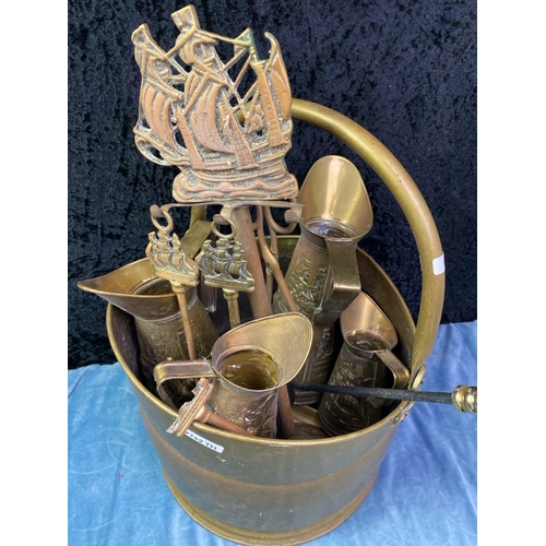 208 - A brass coal bucket containing brass fireside items Inc fire irons etc