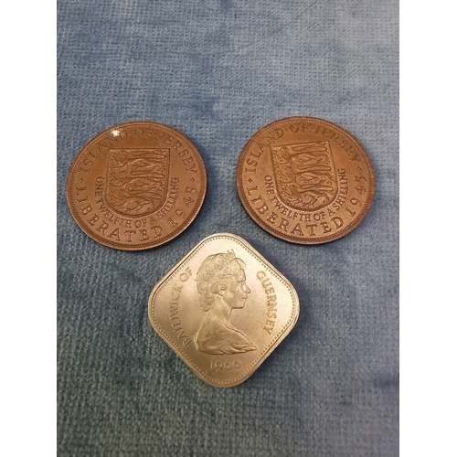 723 - Two ‘Liberated 1945’ Jersey pennies and a Guernsey 10 shilling coin (1066-1966)