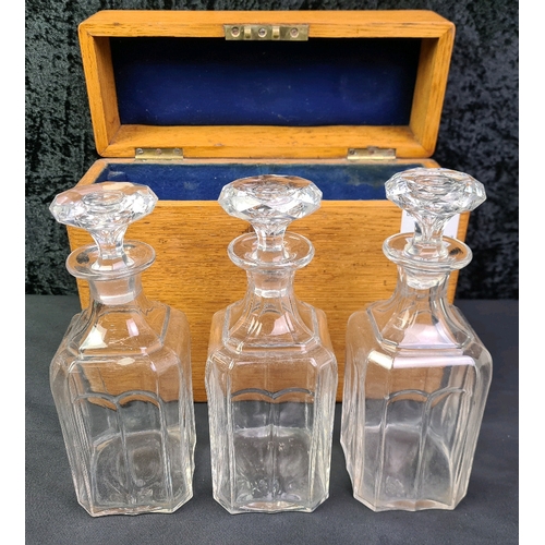 40 - Lockable wooden tantalus box containing three glass decanters, with key