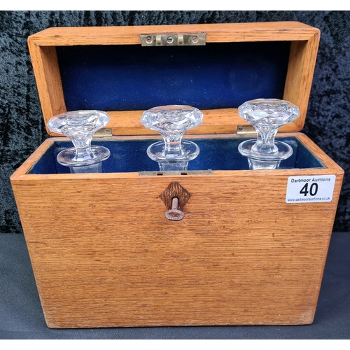 40 - Lockable wooden tantalus box containing three glass decanters, with key