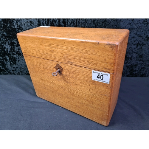 40 - Lockable wooden tantalus box containing three glass decanters, with key