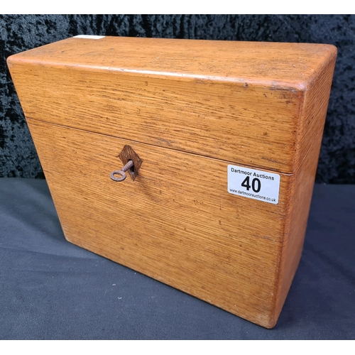 40 - Lockable wooden tantalus box containing three glass decanters, with key