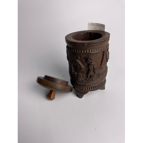 400 - Hand carved wooden lidded cylindrical container with carved village scene, likely African, 16.5cm ta... 