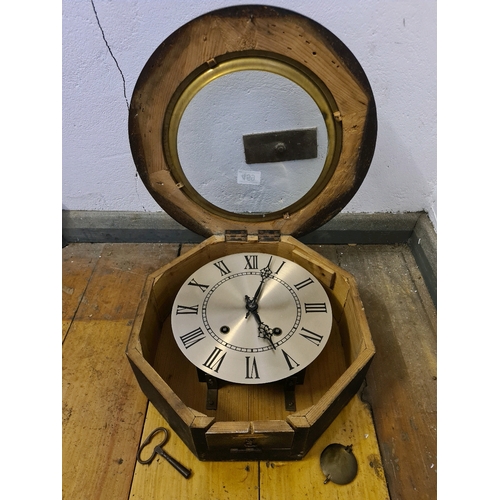 459 - Wooden cased circular wall clock with pendulum and key. Measuring approx 38cm diameter