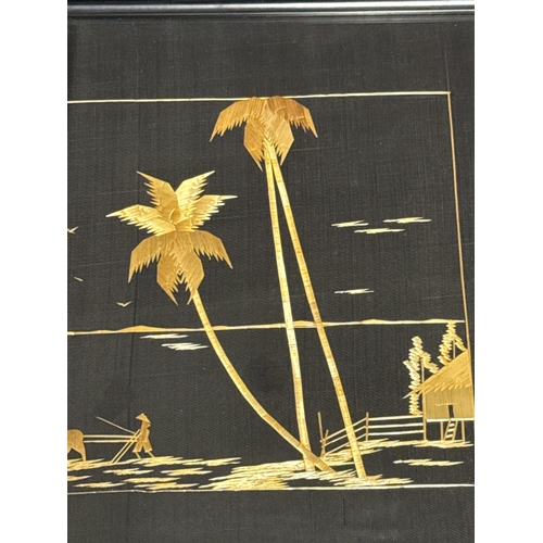 491 - Eastern / Asian straw on black material artworks of farming and fishing scenes. Both measuring appro... 