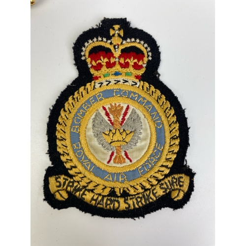 652 - Military badges both lapel and cap, one bearing the motto of the the Royal Air Force's Bomber Comman... 