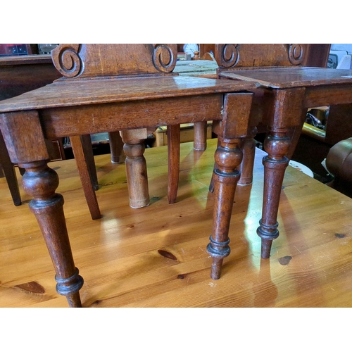 928 - Pair of ecclesiastical oak chairs.  One front leg and seat requires attention.