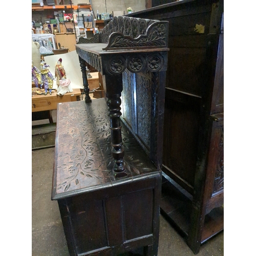 958 - Dark oak sideboard in a Tudor style.  Various shakes and splits to the boards along with signs of ro... 