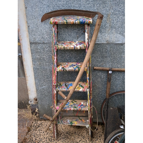 899 - An artfully decorated pair of vintage decorator's steps and a large 2 handed scythe.