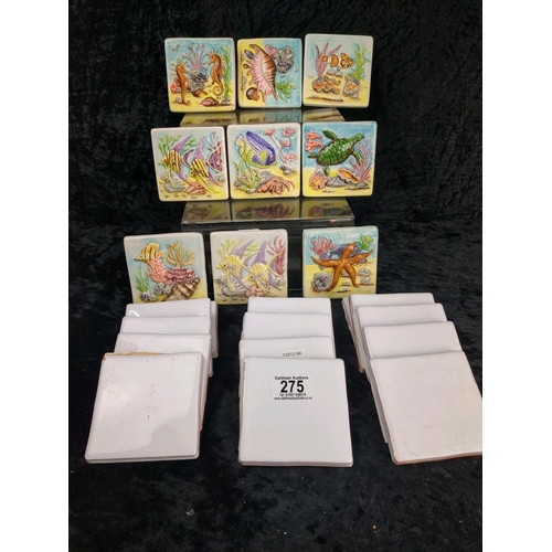 275 - Nine ceramic decorative wall tiles featuring a raised relief of shells and fish (each approx H10cm x... 