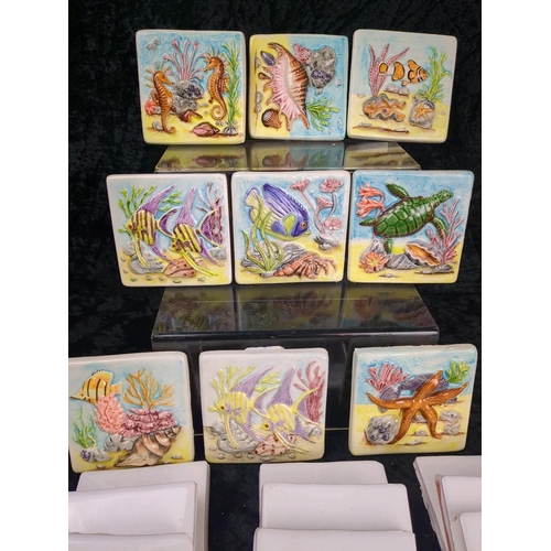 275 - Nine ceramic decorative wall tiles featuring a raised relief of shells and fish (each approx H10cm x... 