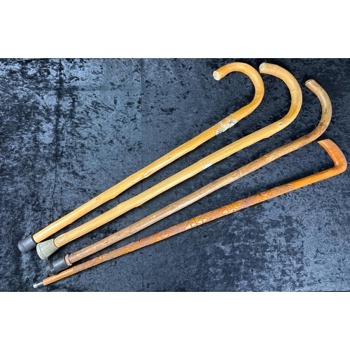 348 - Four wooden walking sticks. One with carving.