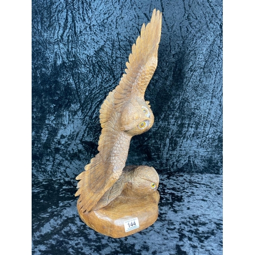 144 - Impressive hand-carved wooden sculpture featuring two owls, one perched on a base and the other in f... 