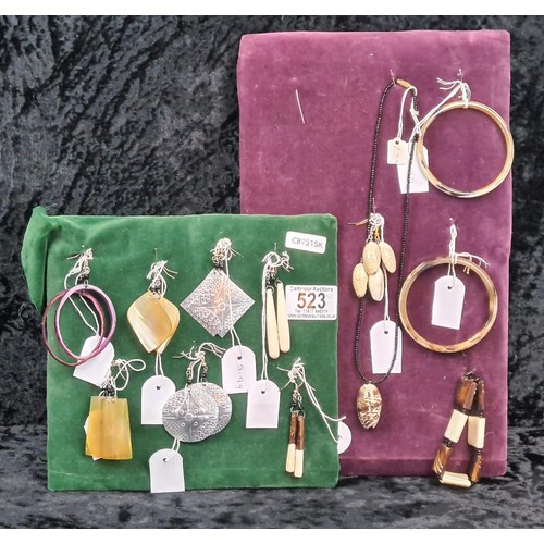 523 - Two velvet cushioned collections of earrings, bangles and a necklace.