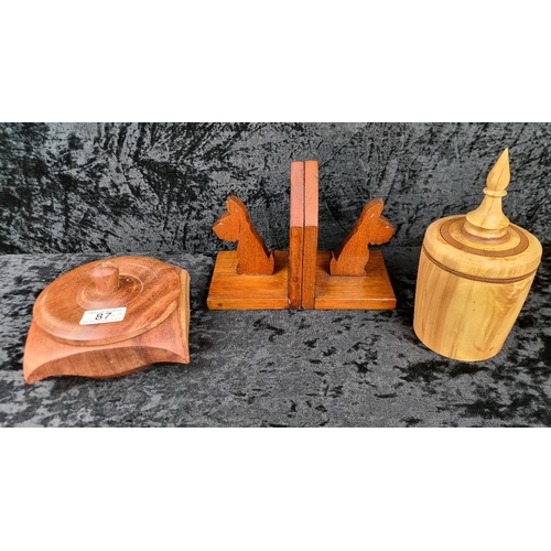 87 - Three hand-carved wooden pieces including a vintage pair of Scottie dog bookends and two lidded trin... 