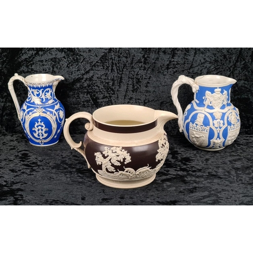 146 - Pair of antique Cobridge bas-relief blue and white jugs (smallest one has repair to lip) and and a b... 