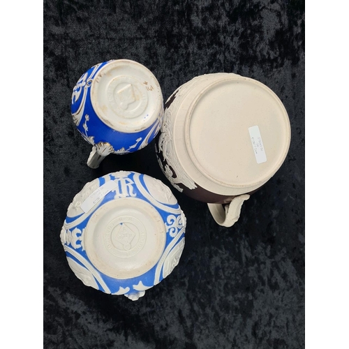 146 - Pair of antique Cobridge bas-relief blue and white jugs (smallest one has repair to lip) and and a b... 