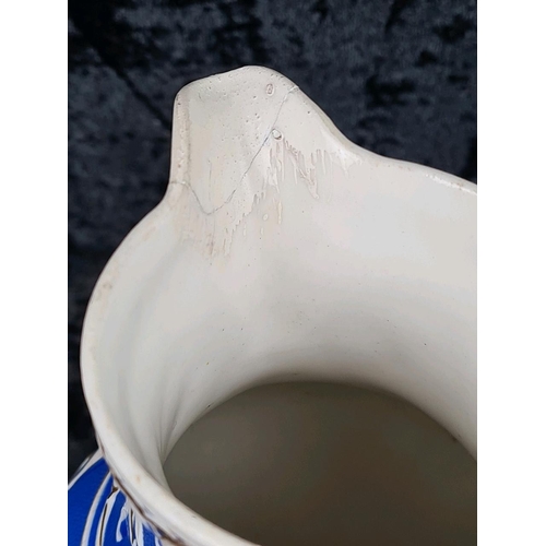 146 - Pair of antique Cobridge bas-relief blue and white jugs (smallest one has repair to lip) and and a b... 