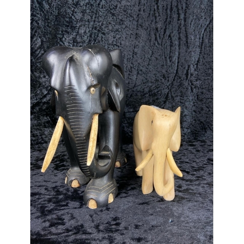 385 - Vintage ebonised hardwood elephant with wooden tusks (approx H23cm) and a smaller wooden companion.