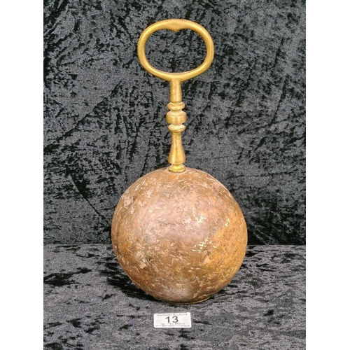 13 - Round mahogany doorstop with ornate brass handle. Approx H30cm.