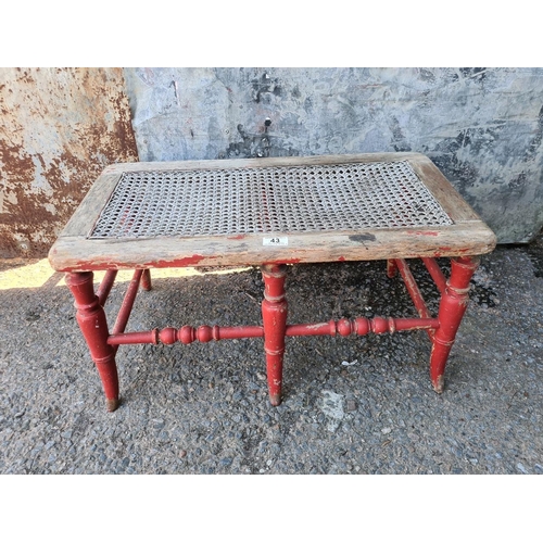 43 - Charming antique bergere cane two-seater stool/bench. Approx H26 x W69 x D37cm.