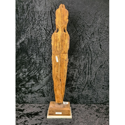 76 - Large hand carved wooden Eastern figure on a plinth. Approx H68cm.