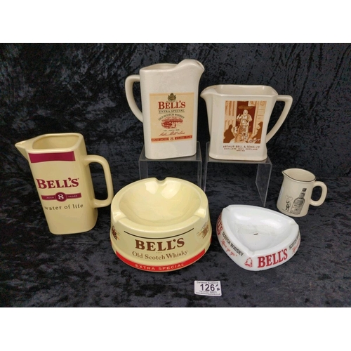 126 - Four vintage Bell's scotch whisky jugs, and two Bell's ashtrays.