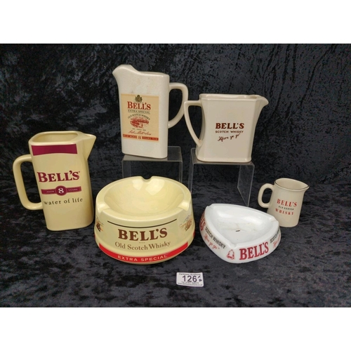 126 - Four vintage Bell's scotch whisky jugs, and two Bell's ashtrays.