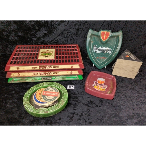 127 - Three bar drip trays, three ashtrays, and assortment of coasters - Murphy's, Heineken, Worthington, ... 