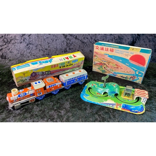 134 - Two vintage tinplate toys - train and clockwork island, both boxed, made in China.