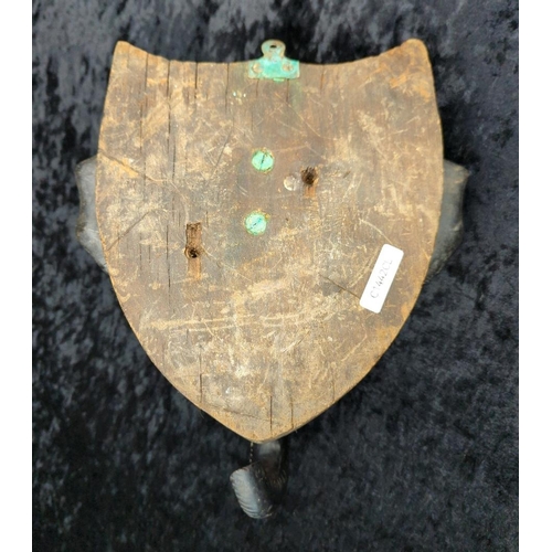 64 - Anglo-Indian carved ebony elephant head wall plaque, on a mahogany backboard and brass candle holder... 