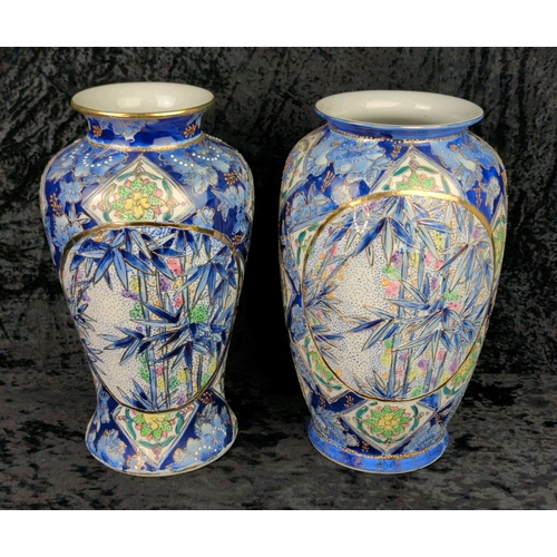 41 - Two large vintage ceramic vases with blue patterns and bamboo plants and gilt detailing. Marked Made... 