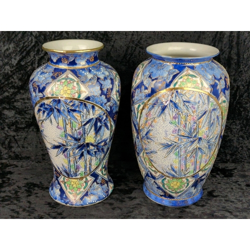 41 - Two large vintage ceramic vases with blue patterns and bamboo plants and gilt detailing. Marked Made... 