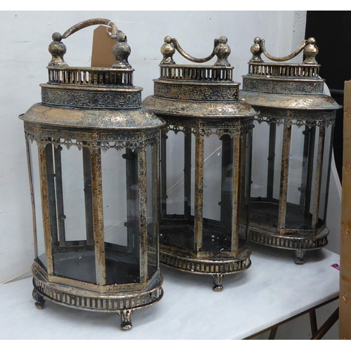 48 - STORM LANTERNS, a set of three, antiqued gilt finish, 158cm H. (3)