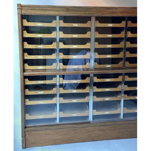 603 - HABERDASHERY CABINET, mid 20th century oak by Pollards with four sliding glazed doors enclosing thir... 