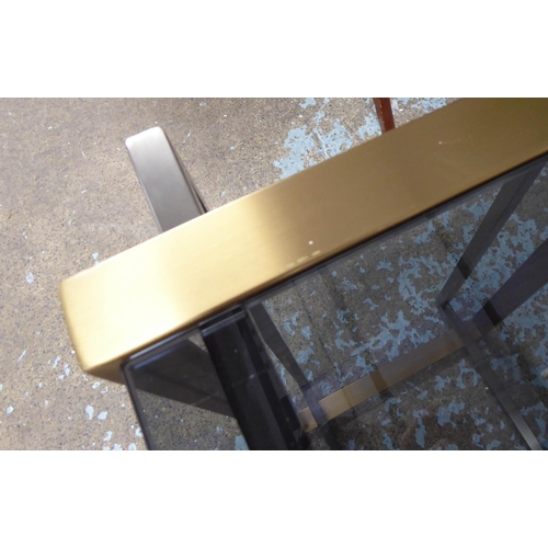 84 - CONSOLE TABLE, the smoked glass top on a metal two tone base, 41cm D x 77cm H x 130cm W.