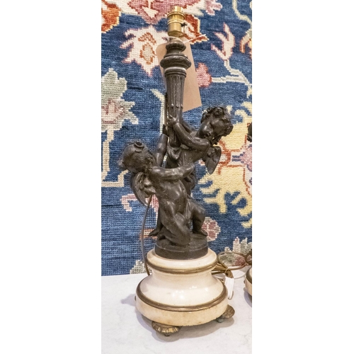 395 - TABLE LAMPS, a pair, 57cm H, bronzed metal, cherubs holding aloft a torchiere, on rounded marble and... 