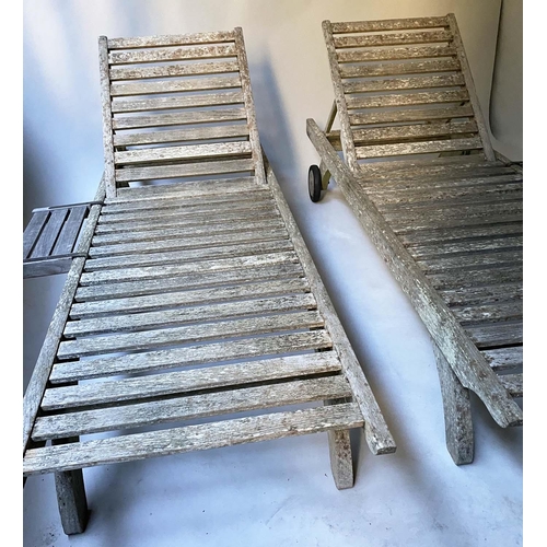 479 - SUN LOUNGERS BY BARLOW TYRIE, a pair, weathered teak with rising back rest, drinks supports and whee... 