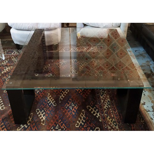 557 - LOW TABLE, 42cm H x 105cm W, ebonised with square glass top.