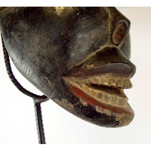 370 - BAMOUR MASK, carved and painted wood on a metal stand with a wooden base, Cameroon, 100cm x 33cm.