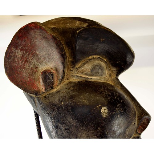 370 - BAMOUR MASK, carved and painted wood on a metal stand with a wooden base, Cameroon, 100cm x 33cm.