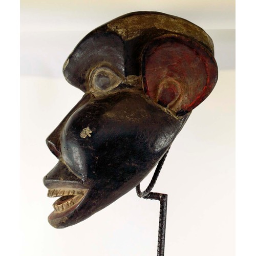 370 - BAMOUR MASK, carved and painted wood on a metal stand with a wooden base, Cameroon, 100cm x 33cm.