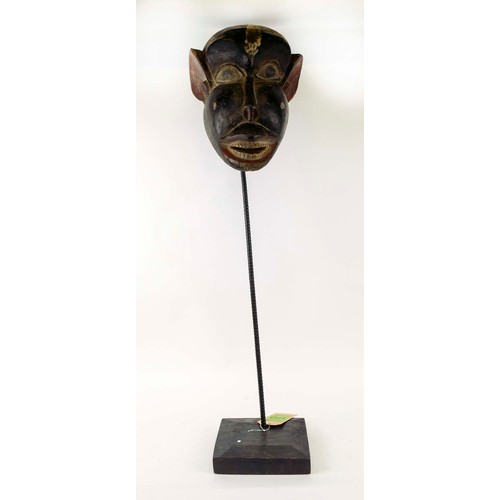 370 - BAMOUR MASK, carved and painted wood on a metal stand with a wooden base, Cameroon, 100cm x 33cm.