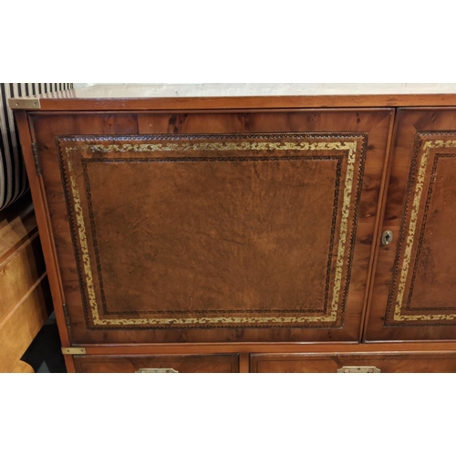 258 - CAMPAIGN STYLE COCKTAIL CABINET, yewwood with two leather panelled doors enclosing glass shelves and... 